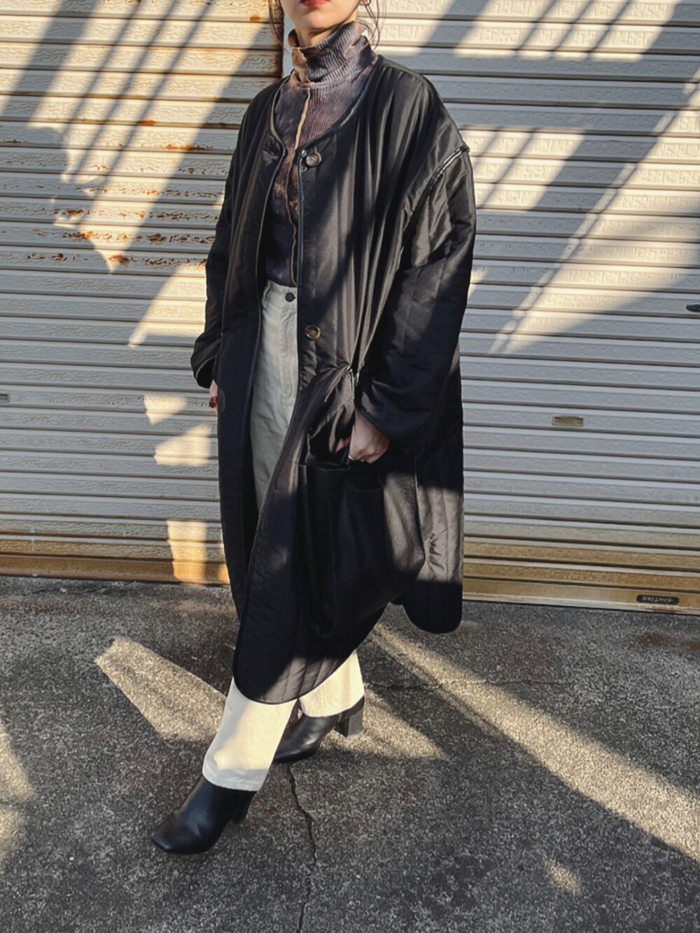 オレンジ系のTシャツ/カットソー、ホワイト系のその他パンツ、ブラック系のハンドバッグを着用したレディースの冬コーディネートの2枚目の写真