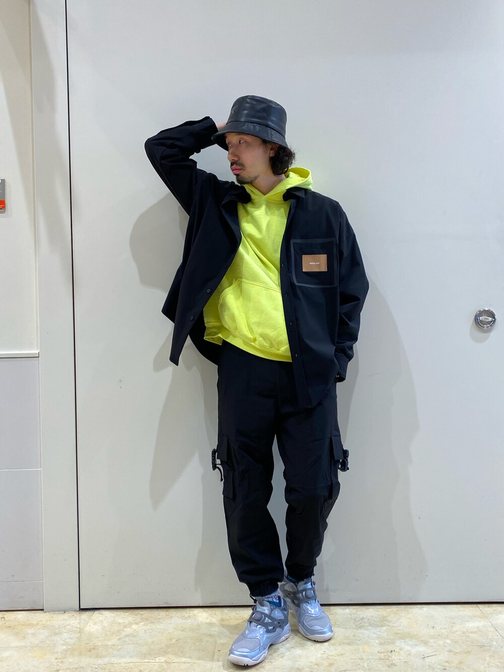 ブラック系のシャツ/ブラウス、ブラック系のカーゴパンツ、シルバー系のスニーカーを着用したメンズの春コーディネートの2枚目の写真