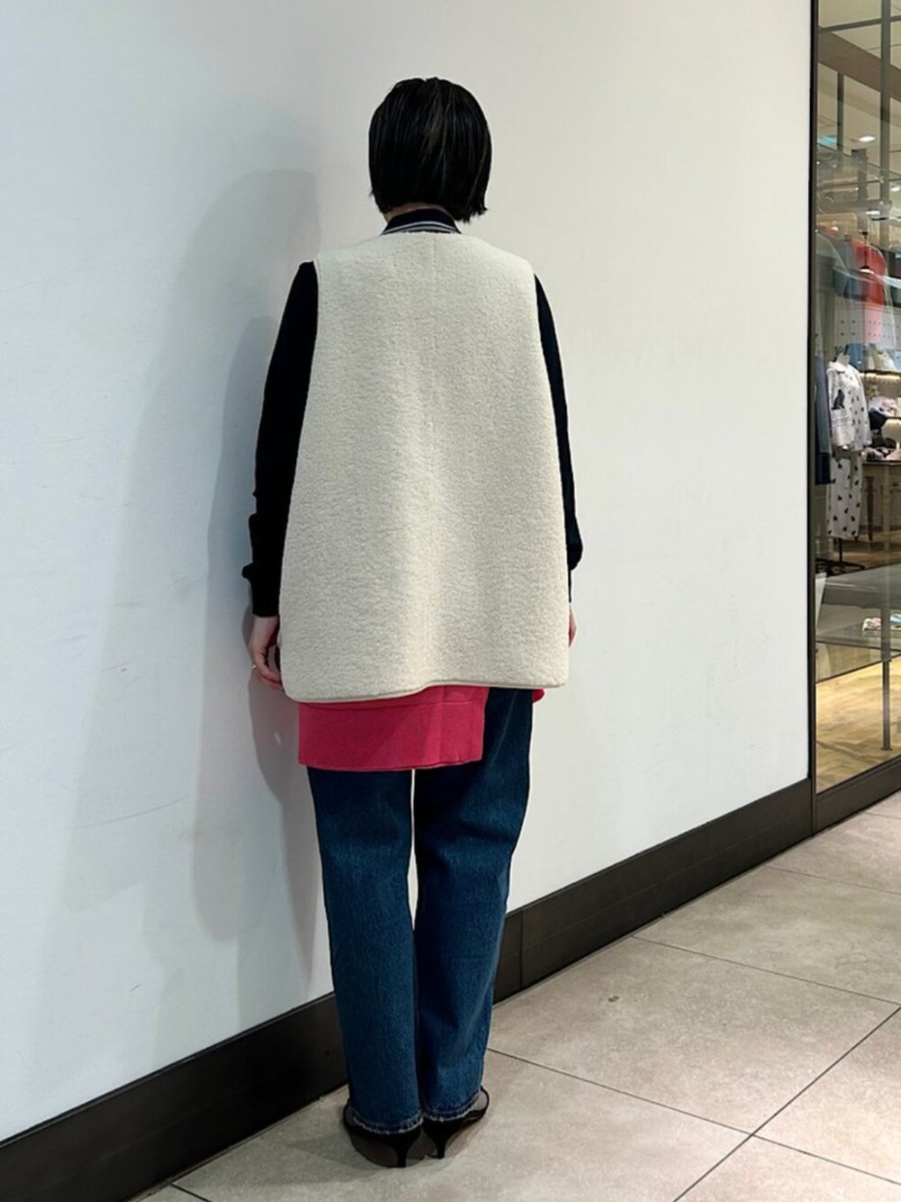 ブルー系のデニムパンツ、ホワイト系のその他アウター、ピンク系のニット/セーターを着用したレディースの秋コーディネートの2枚目の写真