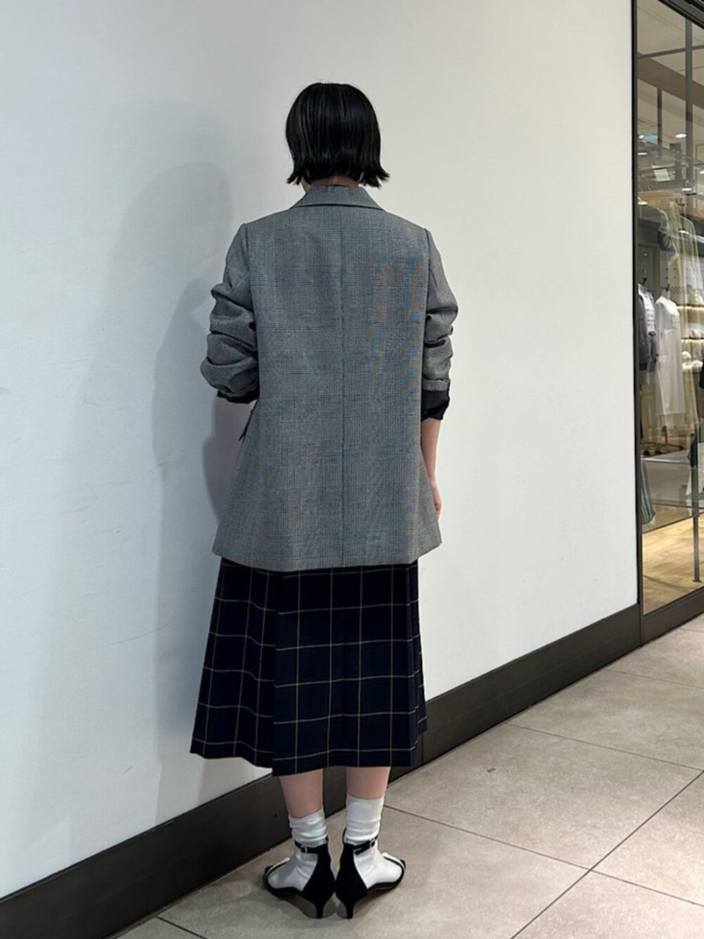 グレー系のテーラードジャケット、ブルー系のシャツ/ブラウス、ブルー系のスカートを着用したレディースの秋コーディネートの3枚目の写真