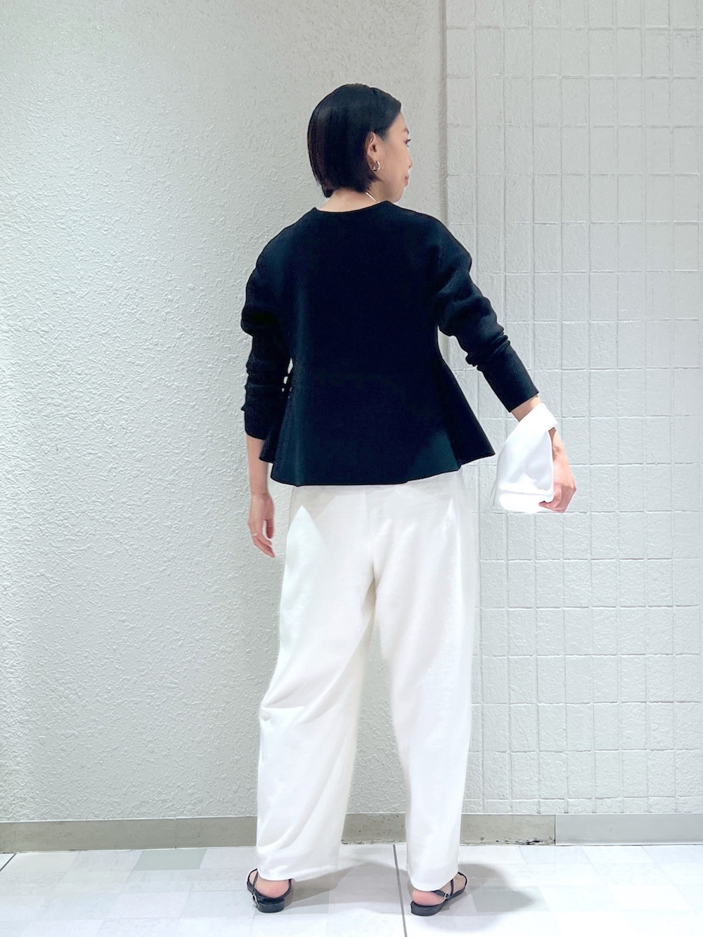 ホワイト系のその他パンツ、ホワイト系のハンドバッグ、ブラック系のニット/セーターを着用したレディースの秋コーディネートの3枚目の写真