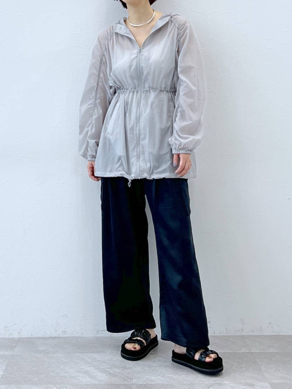 ブラック系のサンダル、グレー系のブルゾン、ブルー系のカーゴパンツを着用したレディースの春コーディネートの5枚目の写真