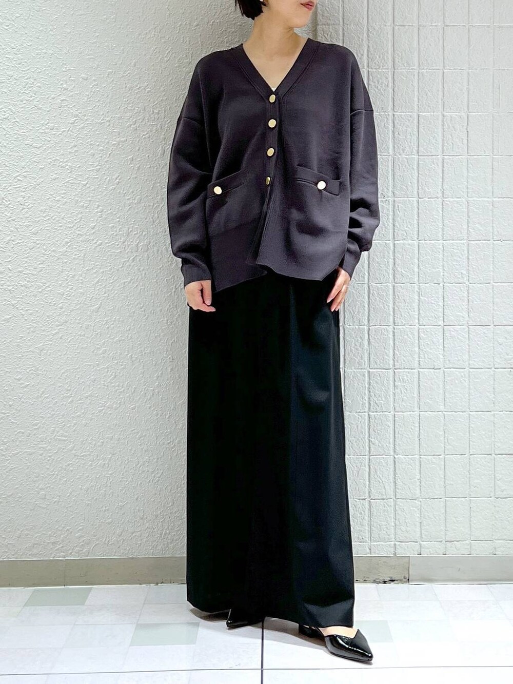 ブラック系のスラックス、ブラック系のパンプス、グレー系のカーディガン/ボレロを着用したレディースの春コーディネートの4枚目の写真