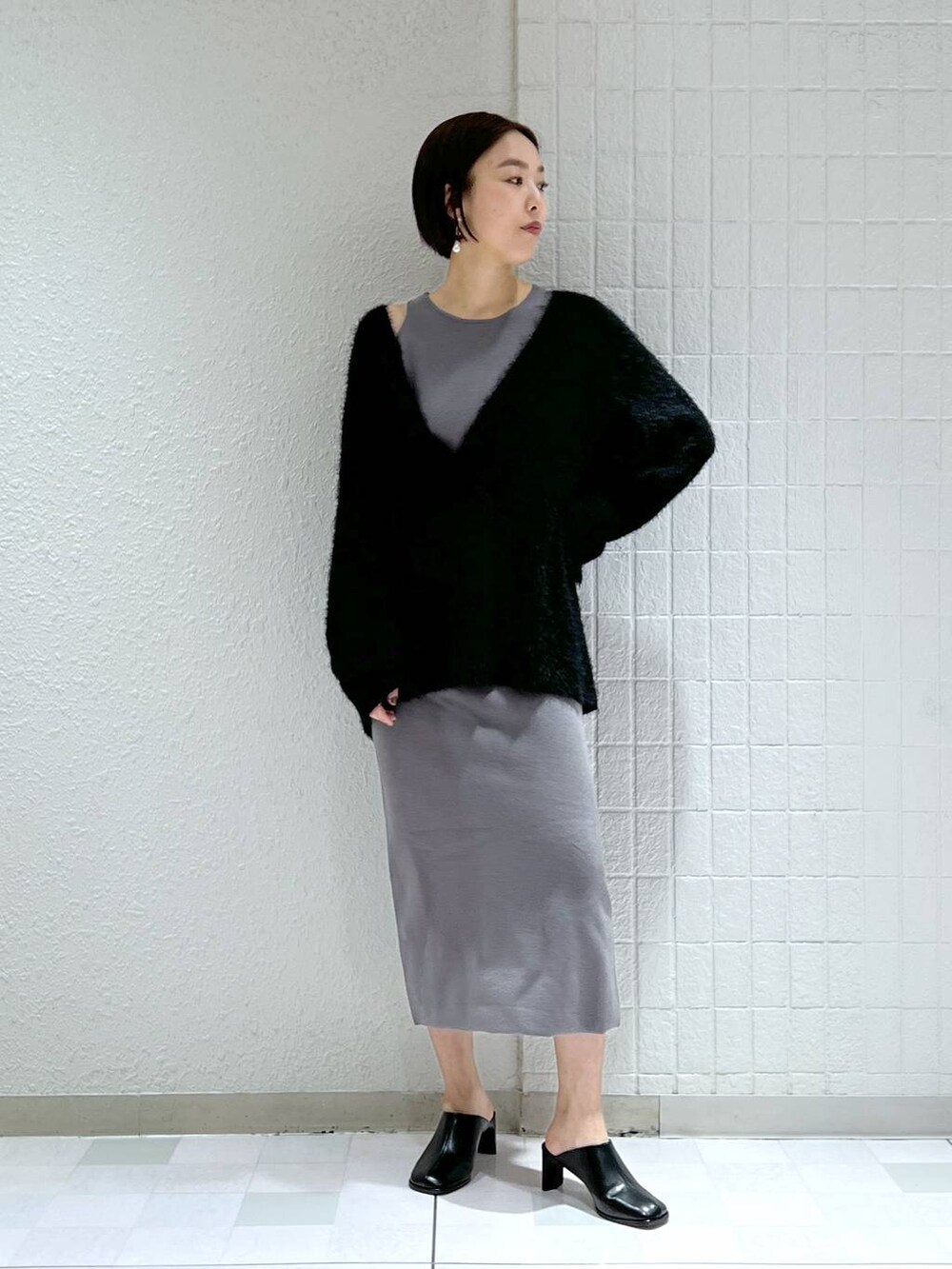 ブラック系のサンダル、グレー系のワンピースを着用したレディースの冬コーディネートの2枚目の写真