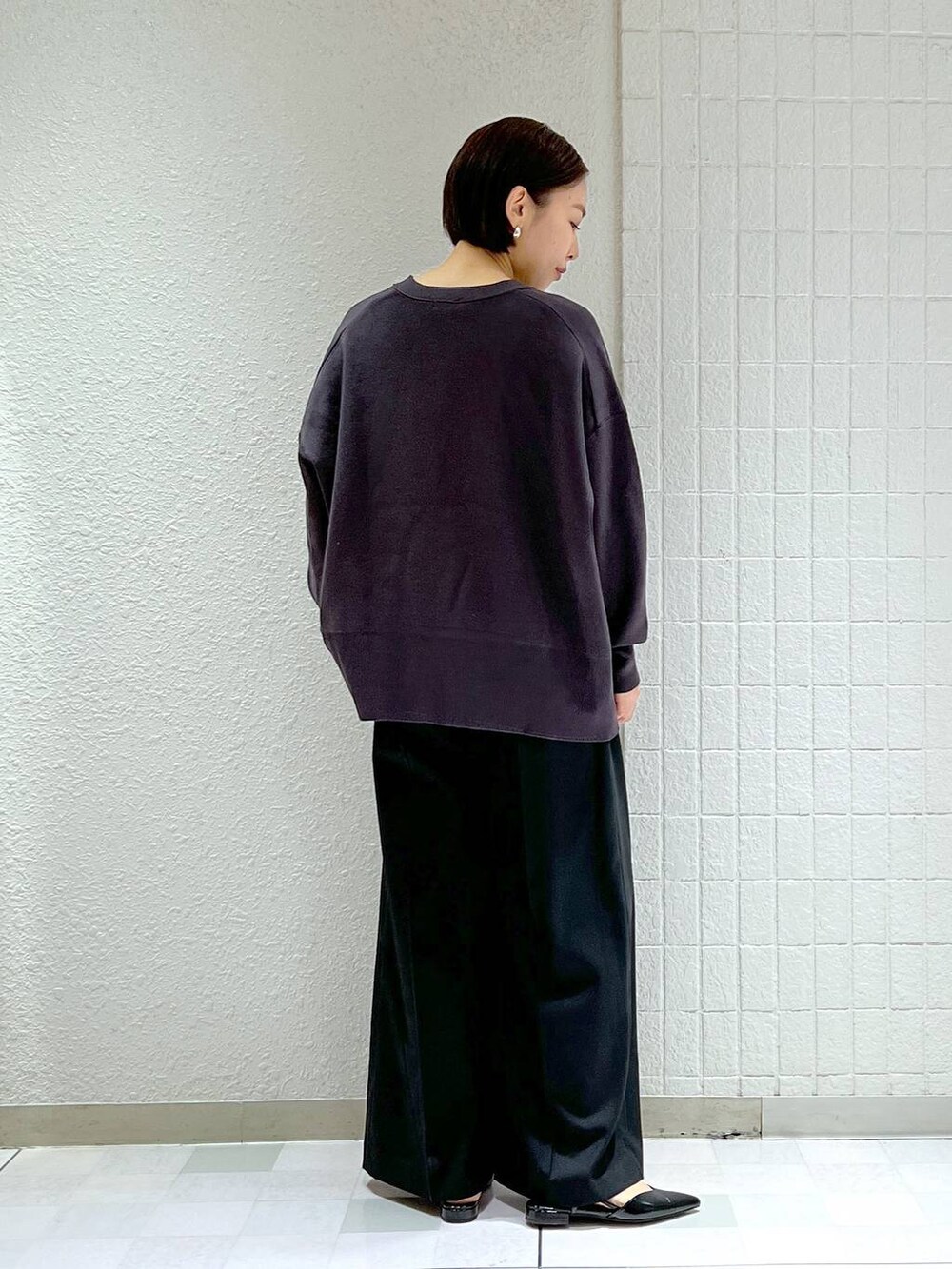 ブラック系のスラックス、ブラック系のパンプス、グレー系のカーディガン/ボレロを着用したレディースの春コーディネートの3枚目の写真