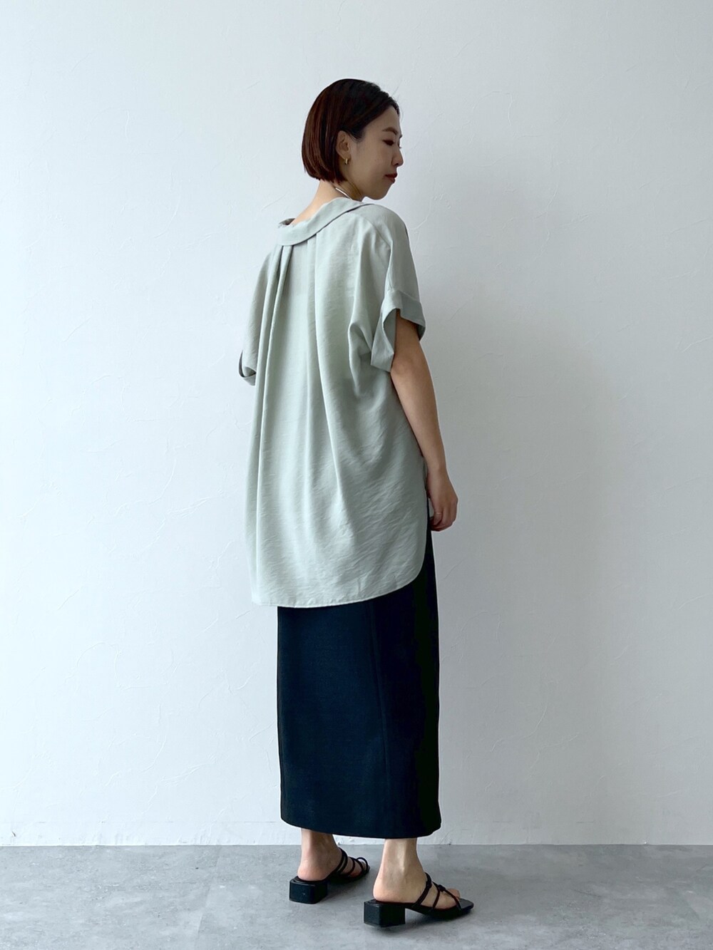 グリーン系のシャツ/ブラウス、ブラック系のスカート、ブラック系のシューズを着用したレディースの夏コーディネートの2枚目の写真