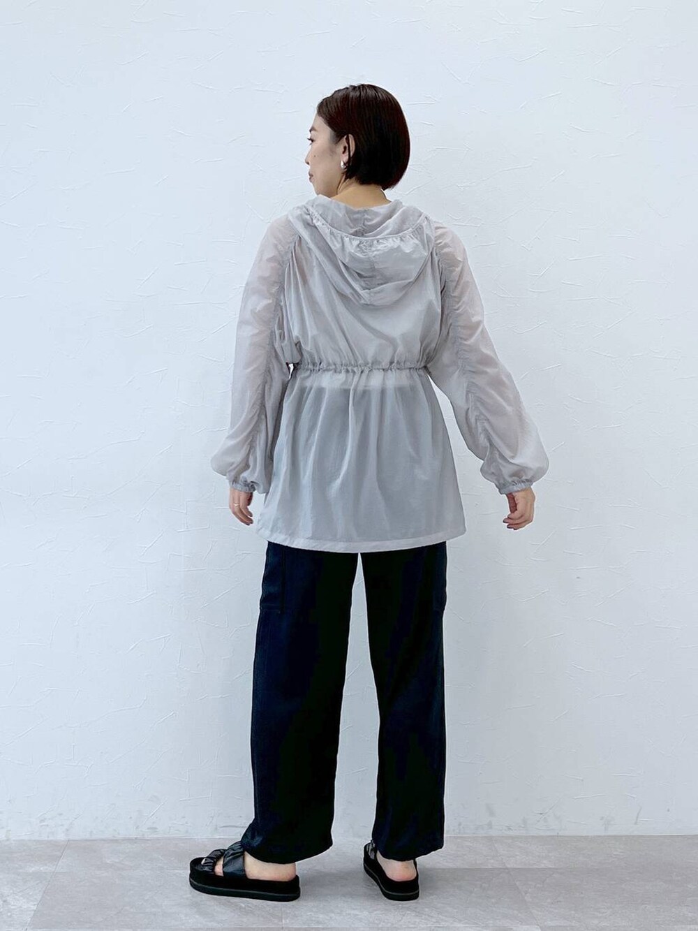 ブラック系のサンダル、グレー系のブルゾン、ブルー系のカーゴパンツを着用したレディースの春コーディネートの3枚目の写真