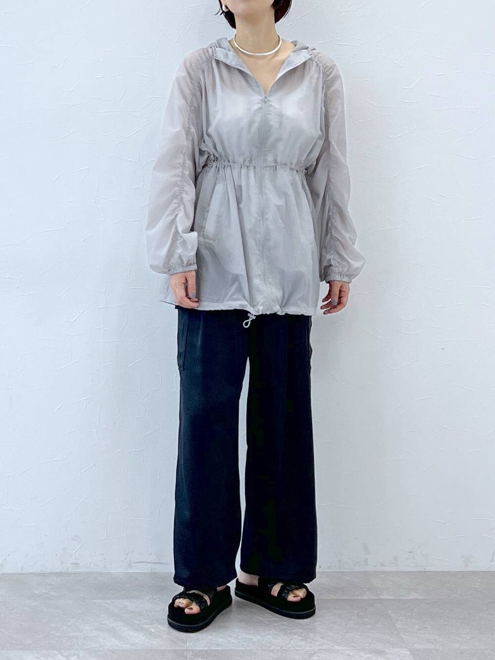 ブラック系のサンダル、グレー系のブルゾン、ブルー系のカーゴパンツを着用したレディースの春コーディネートの4枚目の写真