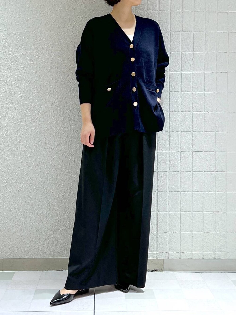 ブラック系のスラックス、ブラック系のパンプス、ブルー系のカーディガン/ボレロを着用したレディースの冬コーディネートの5枚目の写真