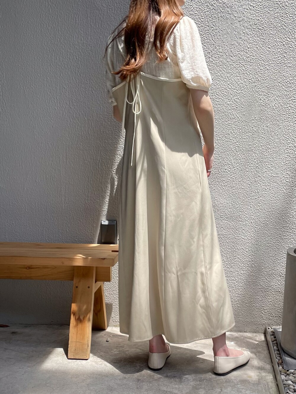 ベージュ系のワンピース、ホワイト系のTシャツ/カットソー、ホワイト系のパンプスを着用したレディースの夏コーディネートの2枚目の写真