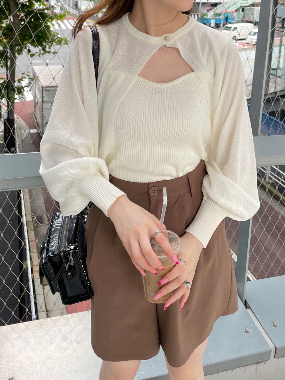 ホワイト系のニット/セーター、ブラウン系のその他パンツ、ブラック系のブーツを着用したレディースの夏コーディネートの2枚目の写真