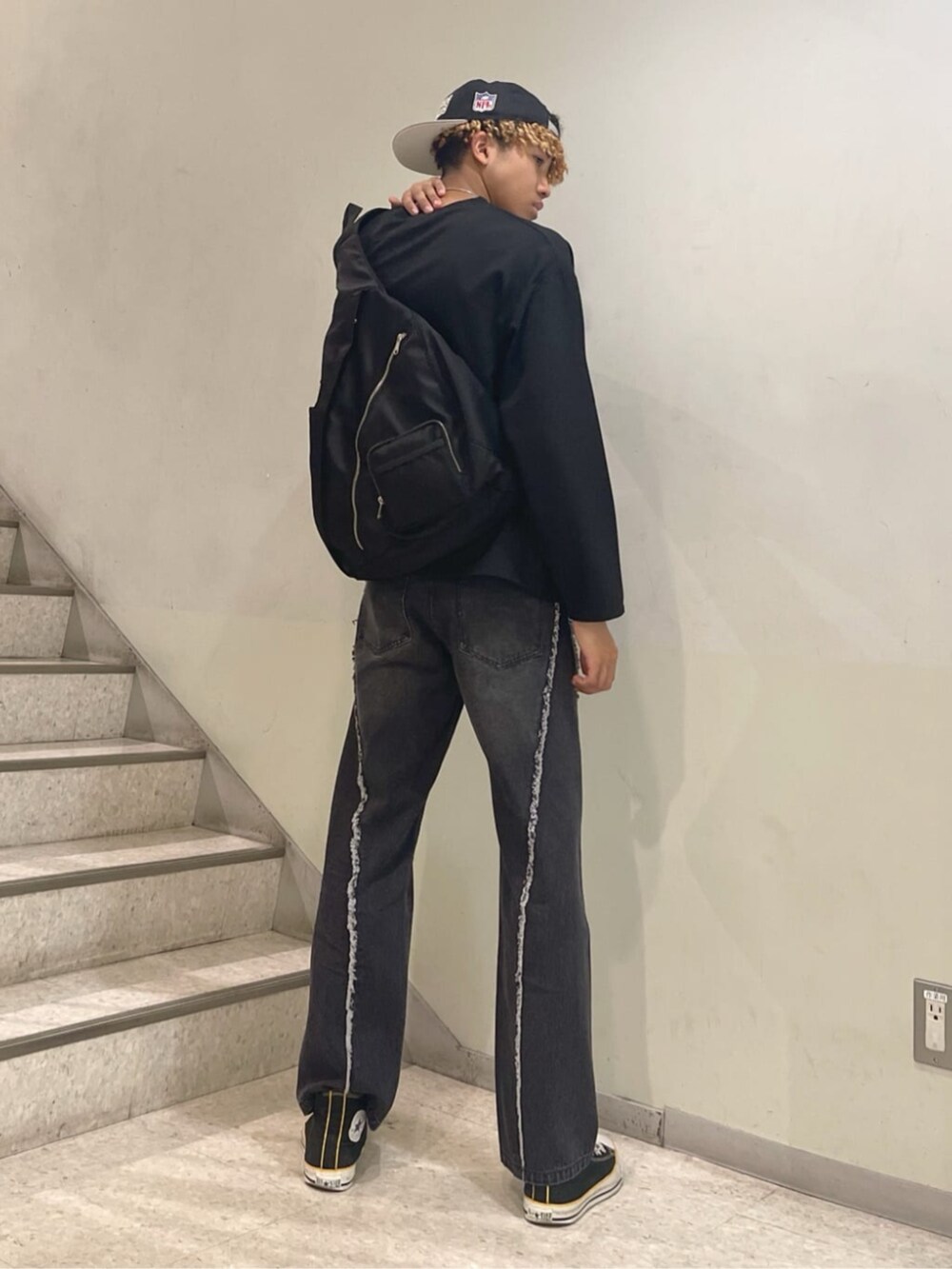 ブラック系のショルダーバッグ、ブラック系のデニムパンツ、ブラック系のアンサンブルを着用したメンズの春コーディネートの2枚目の写真