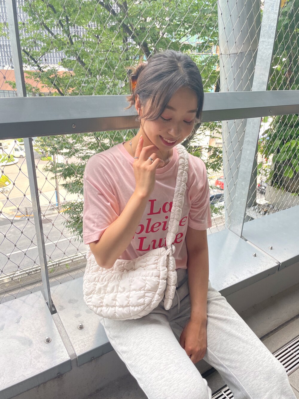 ピンク系のTシャツ/カットソー、グレー系のスウェットパンツ、ホワイト系のショルダーバッグを着用したレディースの夏コーディネートの2枚目の写真