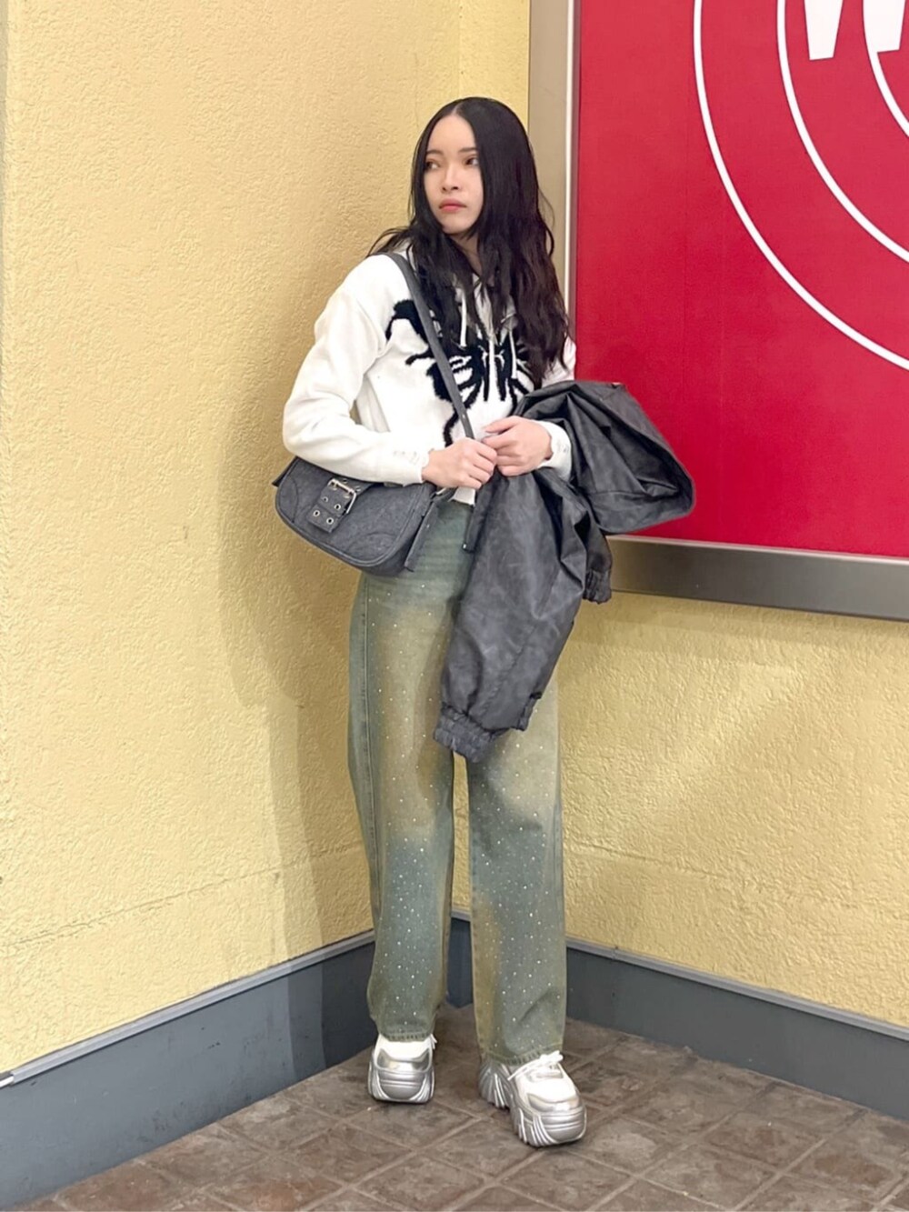 シルバー系のスニーカー、ホワイト系のカーディガン/ボレロ、グレー系のブルゾンを着用したレディースの冬コーディネートの2枚目の写真