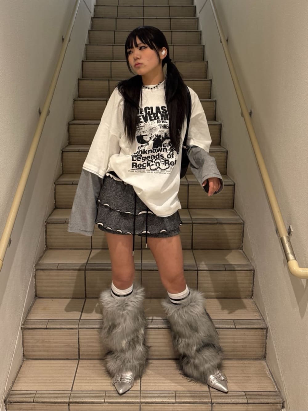 ブラック系のスカート、ブラック系のボストンバッグ、ホワイト系のパーカーを着用したレディースの春コーディネートの2枚目の写真