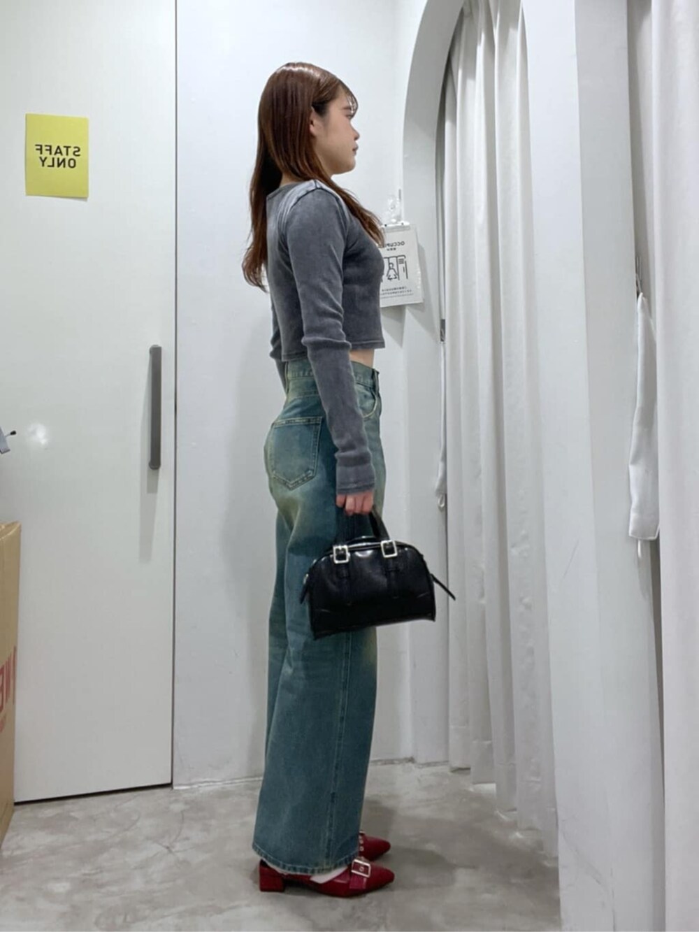 ブラック系のショルダーバッグ、ブラック系のTシャツ/カットソー、ブルー系のデニムパンツを着用したレディースの春コーディネートの2枚目の写真