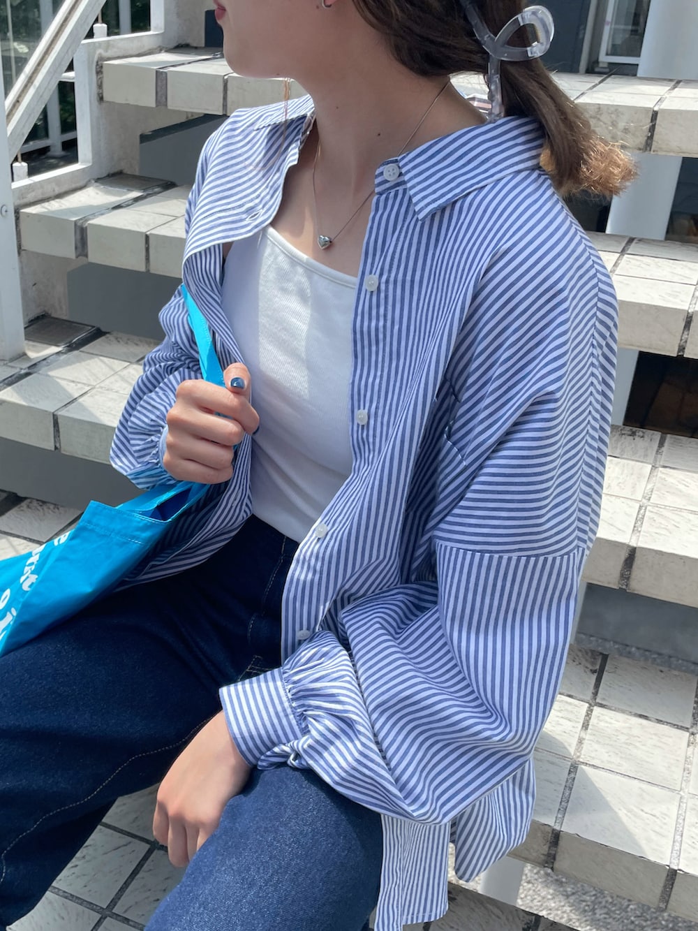 ブルー系のシャツ/ブラウス、ホワイト系のキャミソール、ブルー系のトートバッグを着用したレディースの夏コーディネートの2枚目の写真