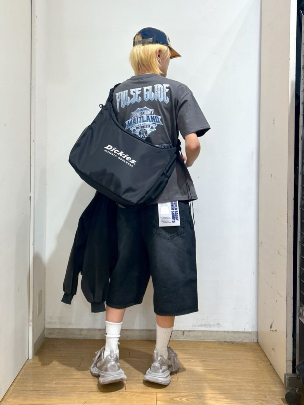 ブラック系のパーカー、ブラック系のショルダーバッグ、ブラック系のデニムパンツを着用したメンズの春コーディネートの3枚目の写真