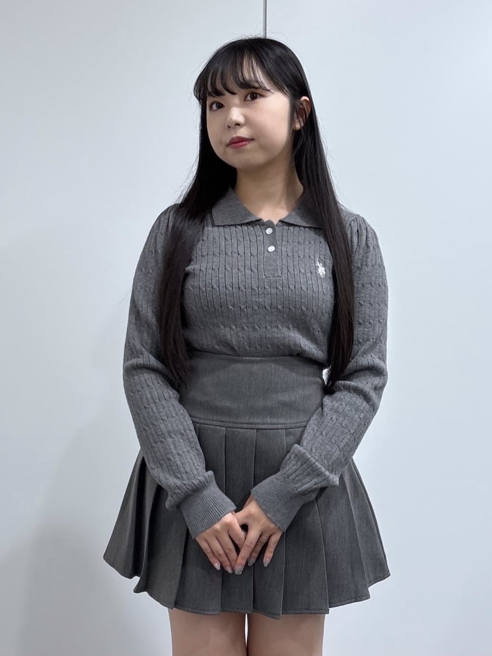 グレー系のニット/セーター、グレー系のスカート、ブラック系のブーツを着用したレディースの秋コーディネートの2枚目の写真