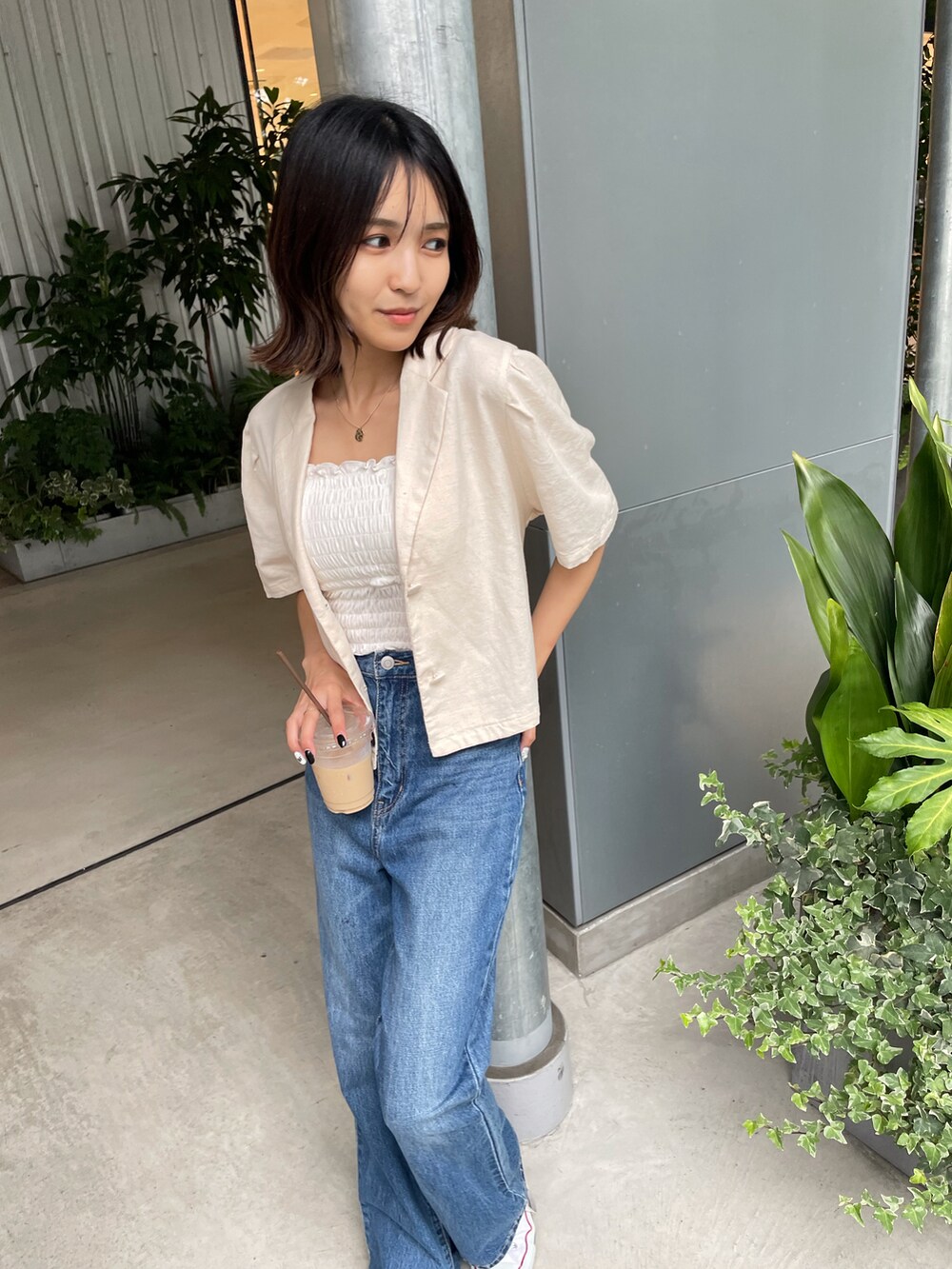 ベージュ系のテーラードジャケット、ホワイト系のキャミソールを着用したレディースの夏コーディネートの2枚目の写真