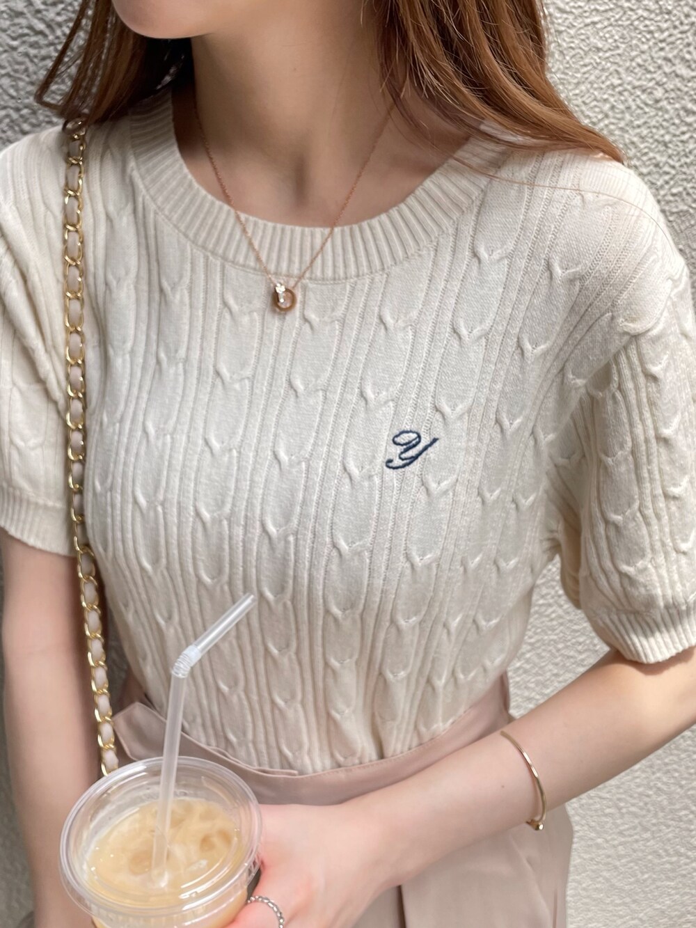 ホワイト系のニット/セーターを着用したレディースの夏コーディネートの2枚目の写真