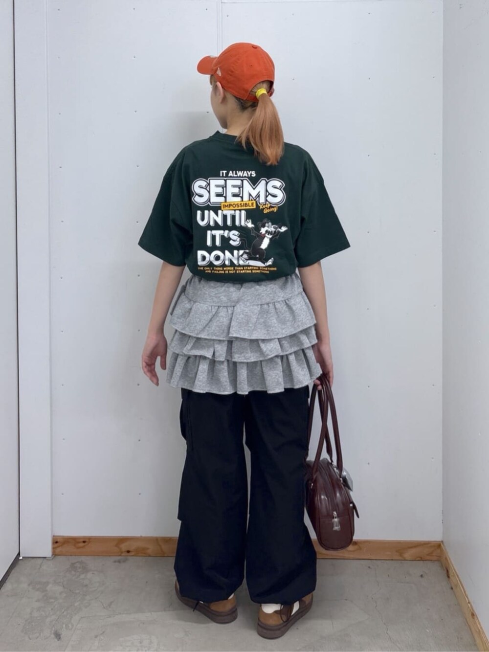 ブラック系のカーゴパンツ、グレー系のスカート、ブラウン系のボストンバッグを着用したレディースの春コーディネートの2枚目の写真