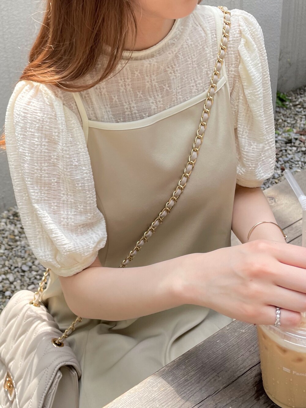 ベージュ系のワンピース、ホワイト系のTシャツ/カットソー、ホワイト系のパンプスを着用したレディースの夏コーディネートの3枚目の写真