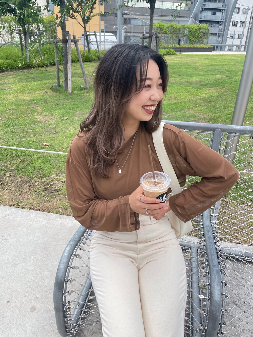 ブラウン系のTシャツ/カットソー、ホワイト系のデニムパンツを着用したレディースの夏コーディネートの2枚目の写真