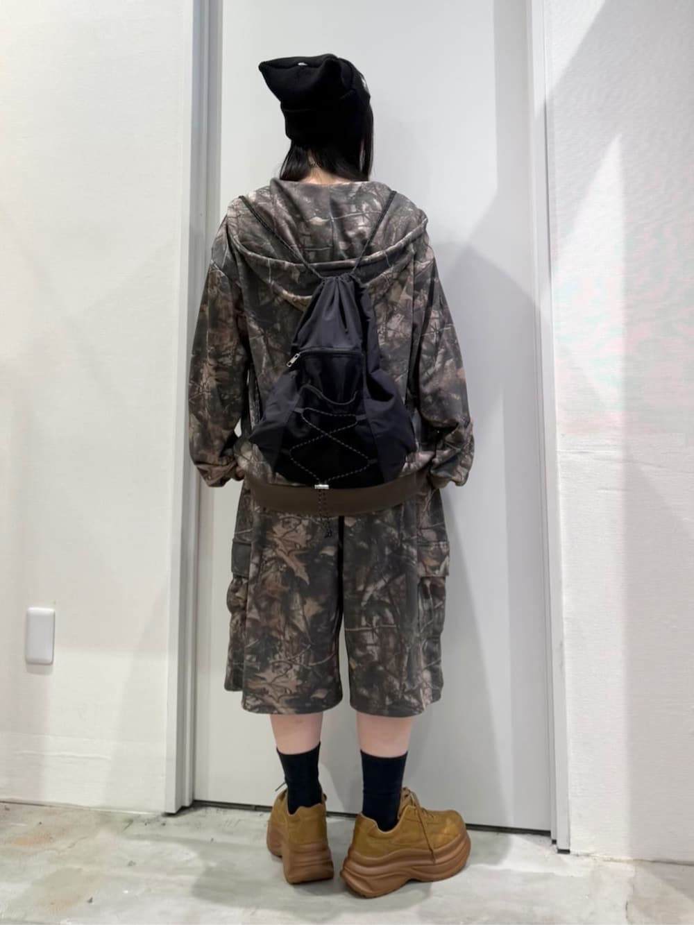 イエロー系のスニーカー、ブラック系のバックパック/リュック、その他のパーカーを着用したレディースの冬コーディネートの2枚目の写真