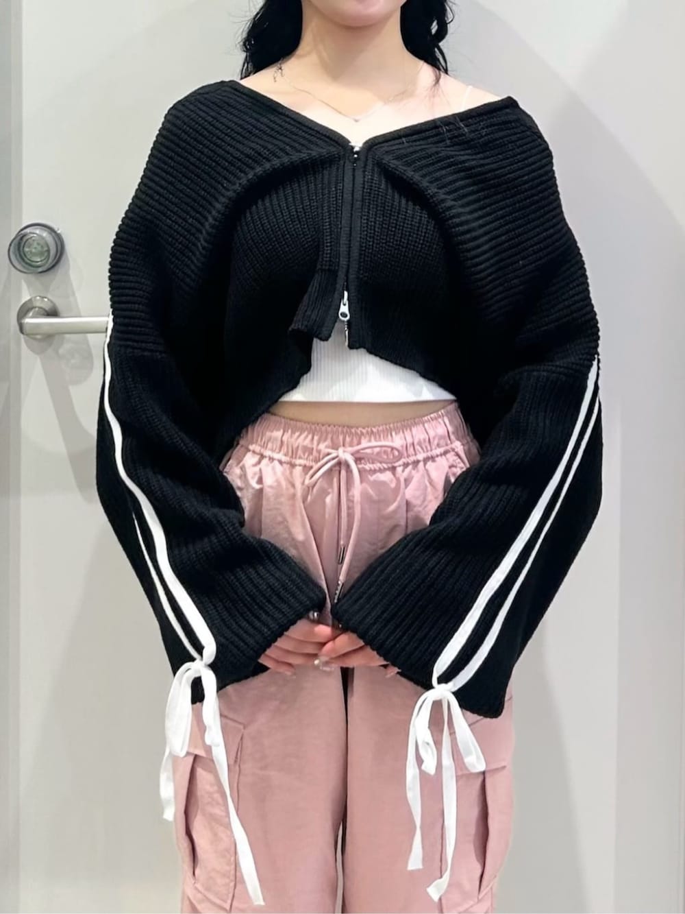 レッド系のハンドバッグ、ホワイト系のスニーカー、ホワイト系のキャミソールを着用したレディースの春コーディネートの2枚目の写真