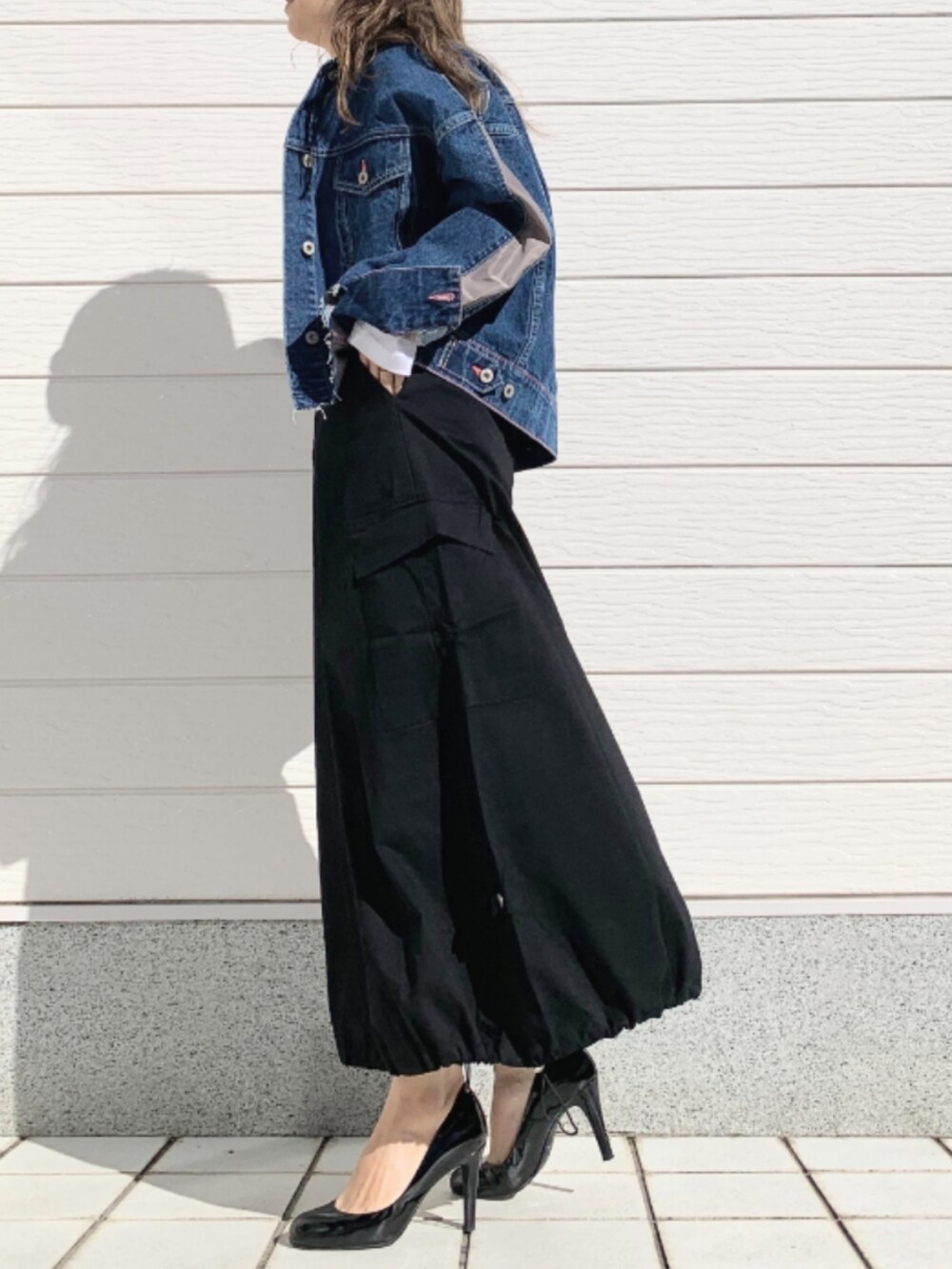 ホワイト系のTシャツ/カットソー、ブルー系のデニムジャケット、ブラック系のスカートを着用したレディースの春コーディネートの3枚目の写真