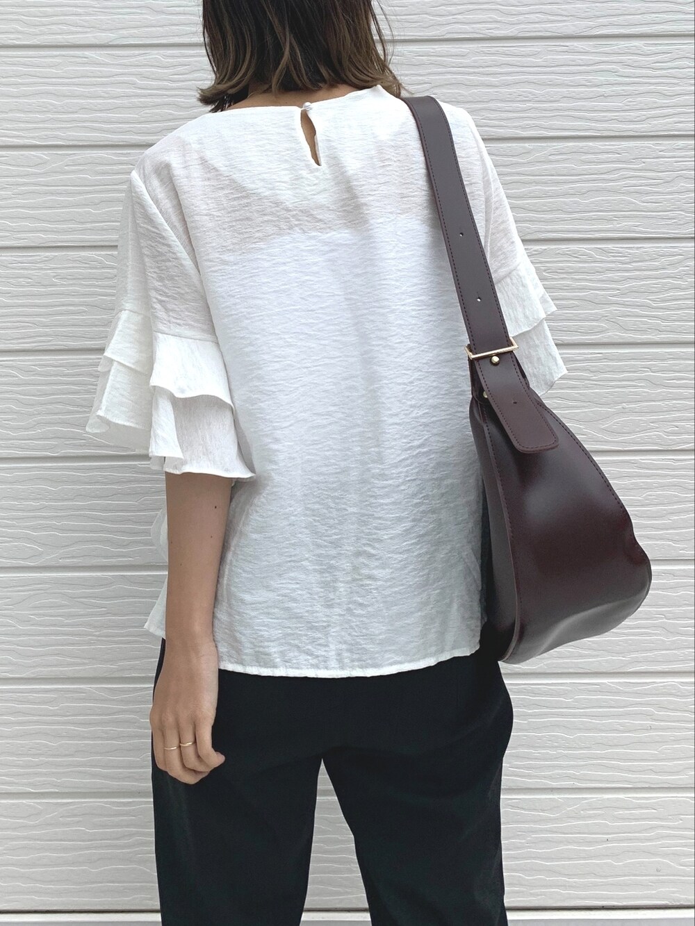 ブラック系のその他パンツ、ブラウン系のショルダーバッグ、ホワイト系のシャツ/ブラウスを着用したレディースの夏コーディネートの2枚目の写真