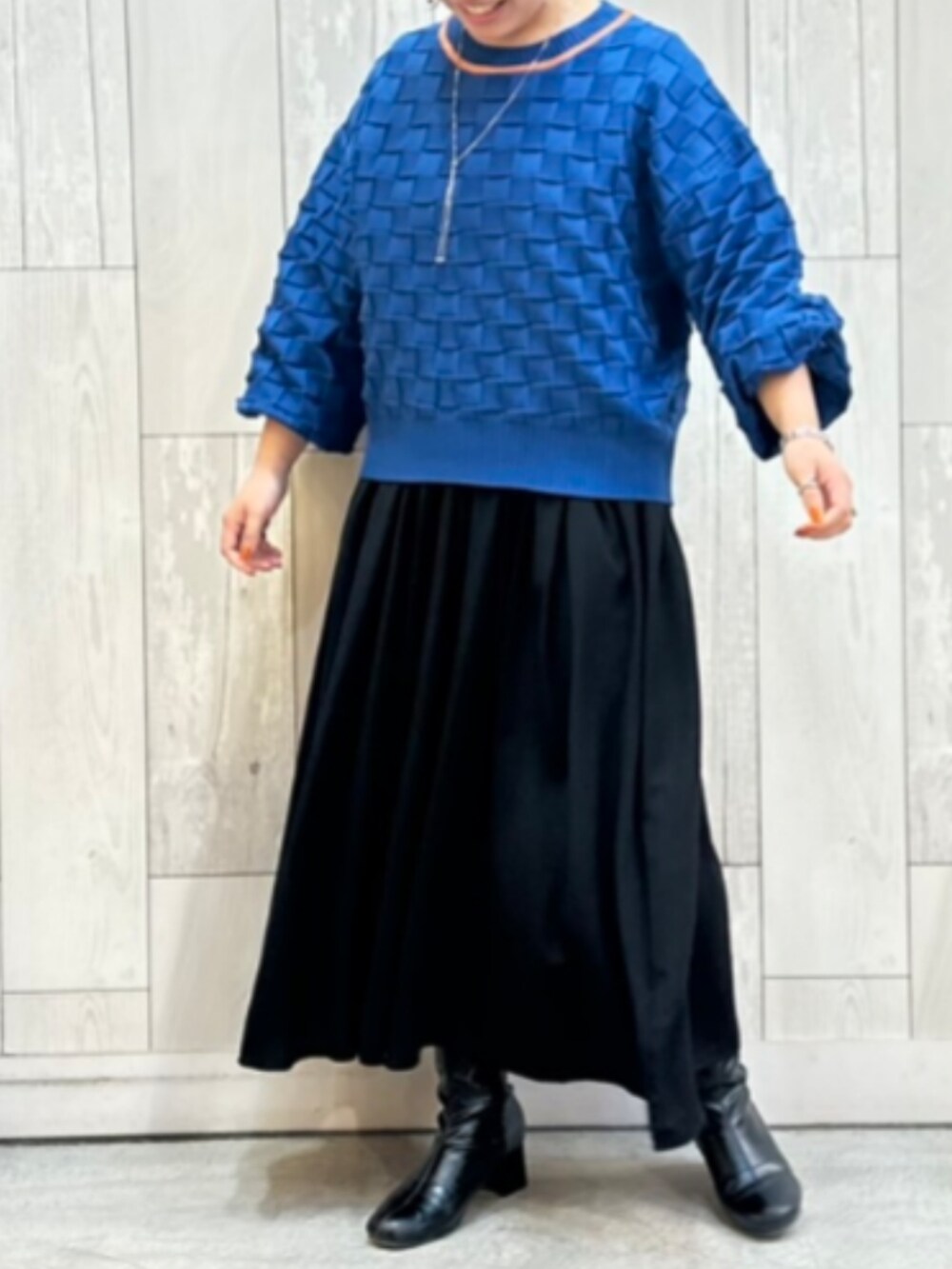 ブルー系のニット/セーター、シルバー系のネックレスを着用したレディースの冬コーディネートの2枚目の写真