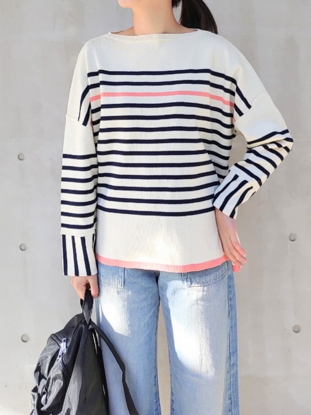 ブルー系のデニムパンツ、ホワイト系のスニーカー、ブラック系のバックパック/リュックを着用したレディースの冬コーディネートの4枚目の写真