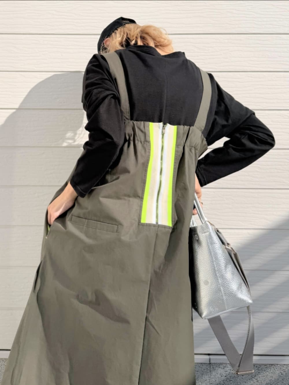 グリーン系のワンピース、ホワイト系のスニーカー、シルバー系のトートバッグを着用したレディースの冬コーディネートの5枚目の写真