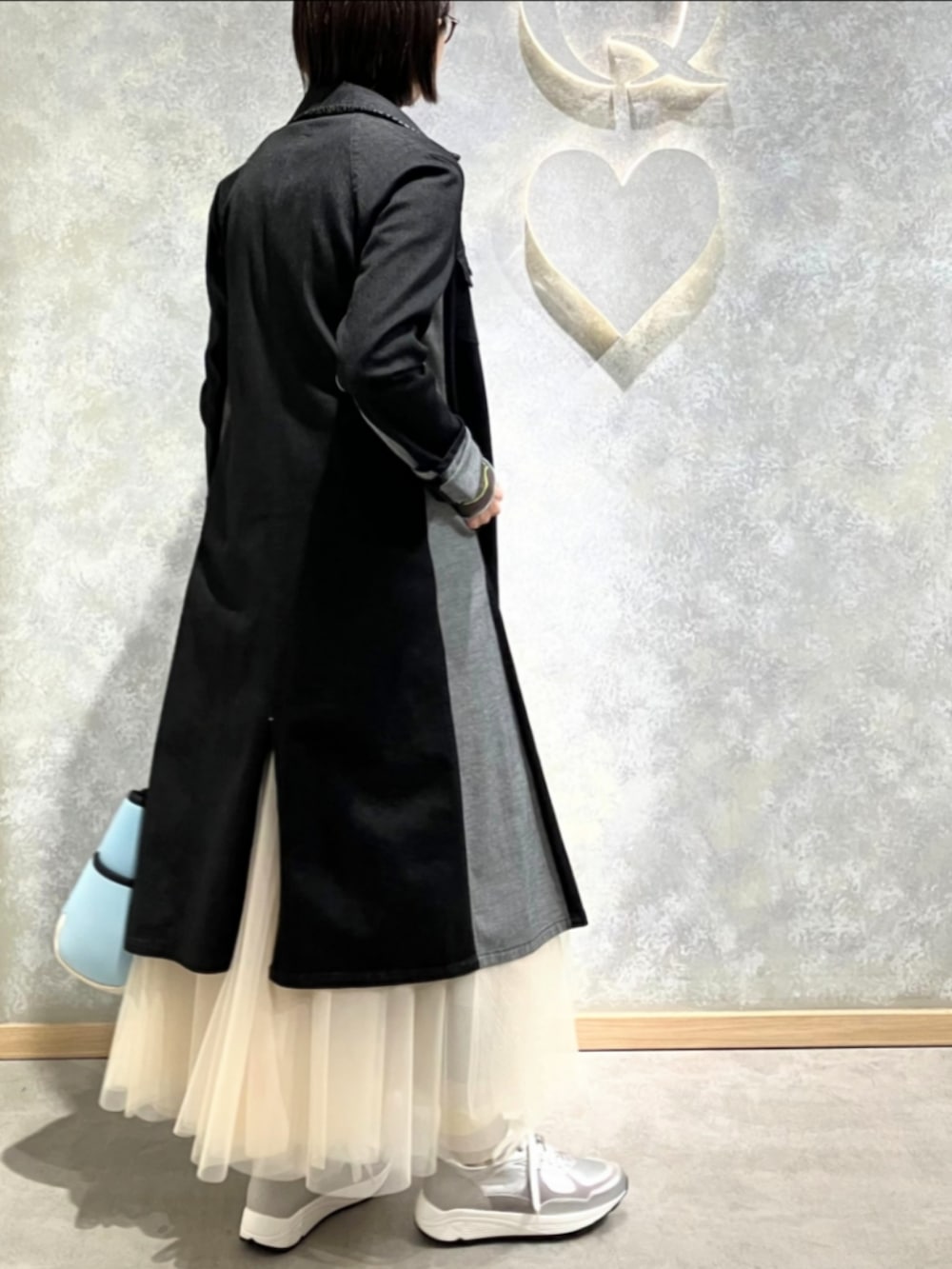 ブルー系のトートバッグ、ゴールド系のスカート、ブラック系のデニムジャケットを着用したレディースの冬コーディネートの4枚目の写真