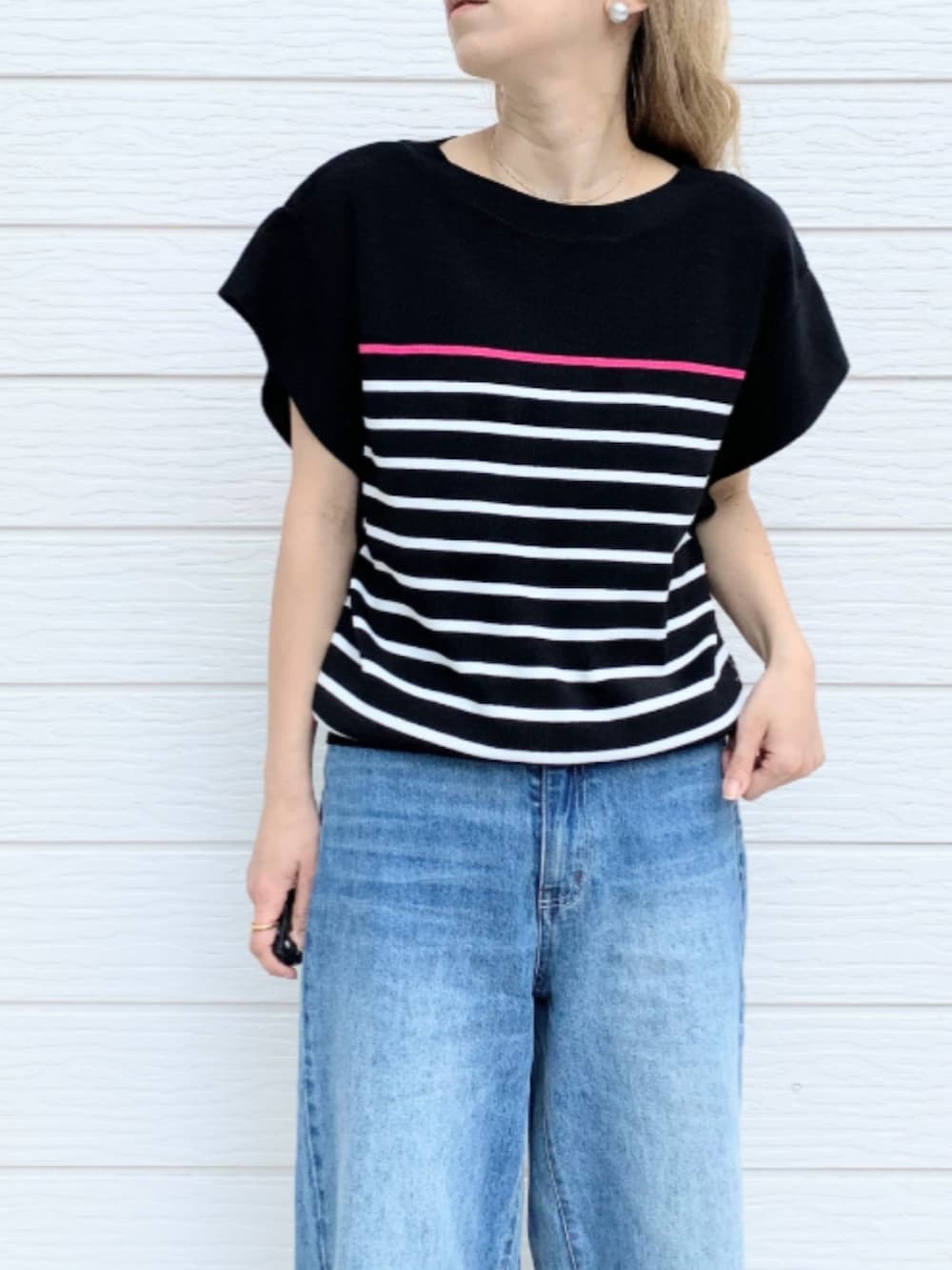 ブルー系のトートバッグ、ブルー系のデニムパンツ、ブラック系のニット/セーターを着用したレディースの春コーディネートの4枚目の写真