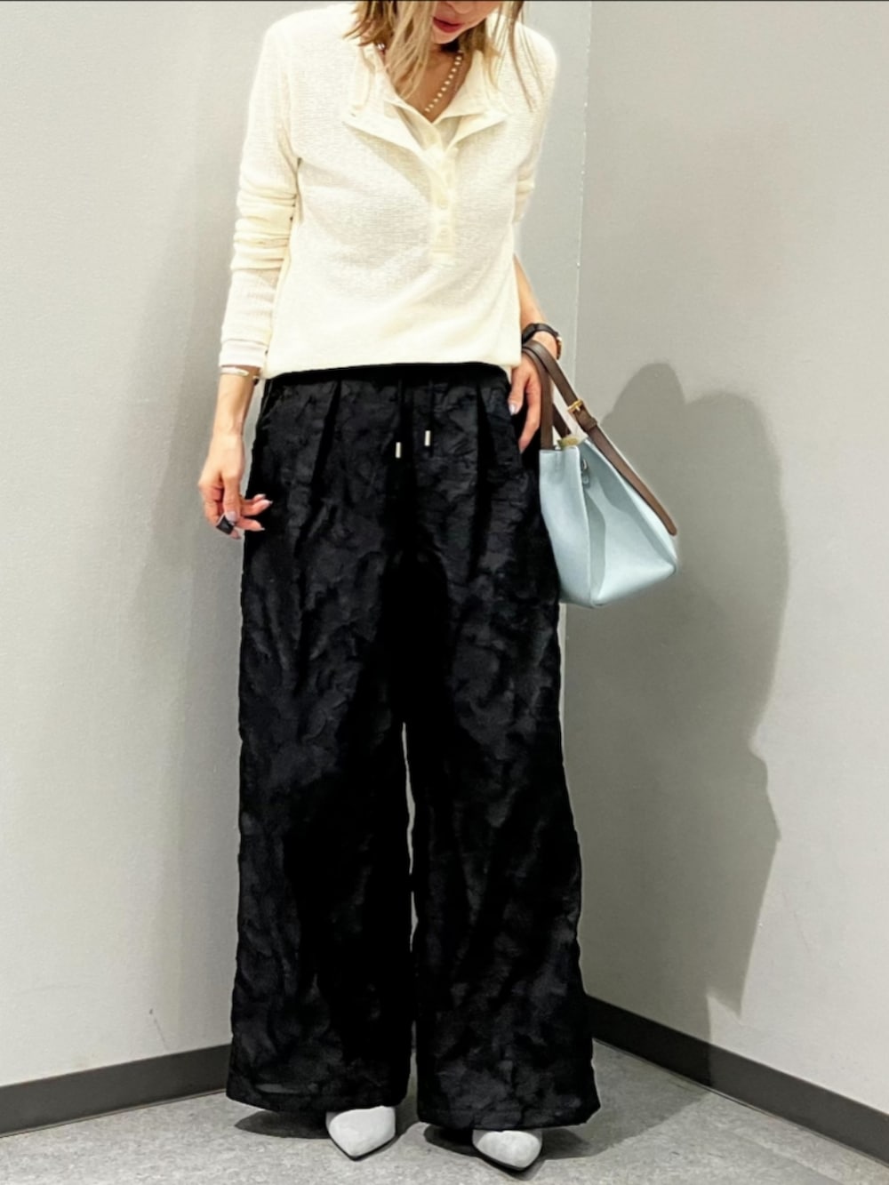 ブルー系のトートバッグ、ブラック系のその他パンツ、ホワイト系のTシャツ/カットソーを着用したレディースの春コーディネートの2枚目の写真