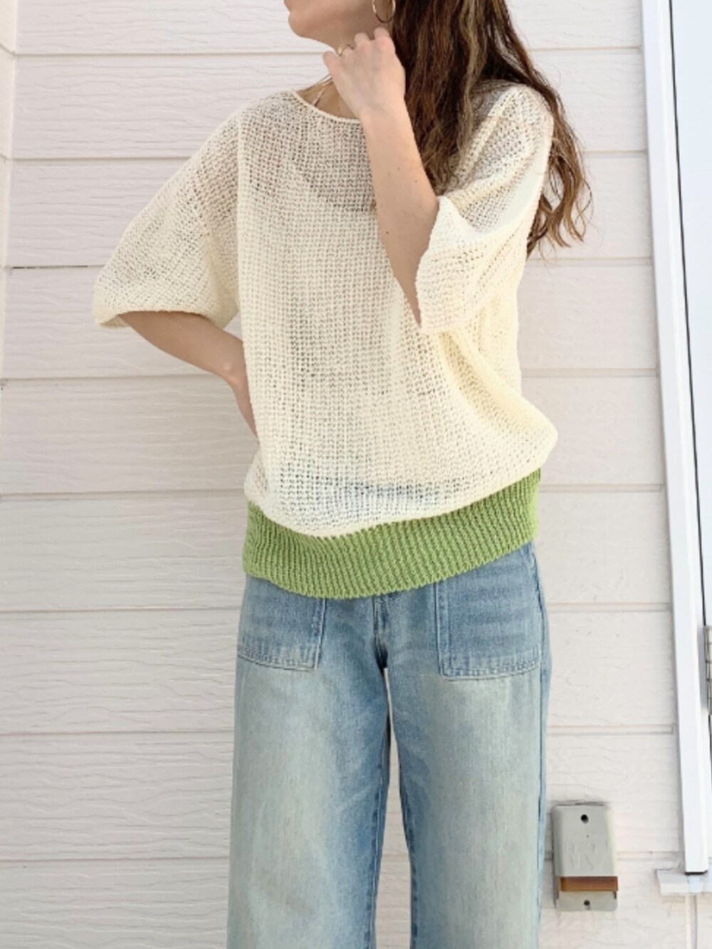 ブルー系のデニムパンツ、ホワイト系のキャミソール、ホワイト系のニット/セーターを着用したレディースの春コーディネートの2枚目の写真