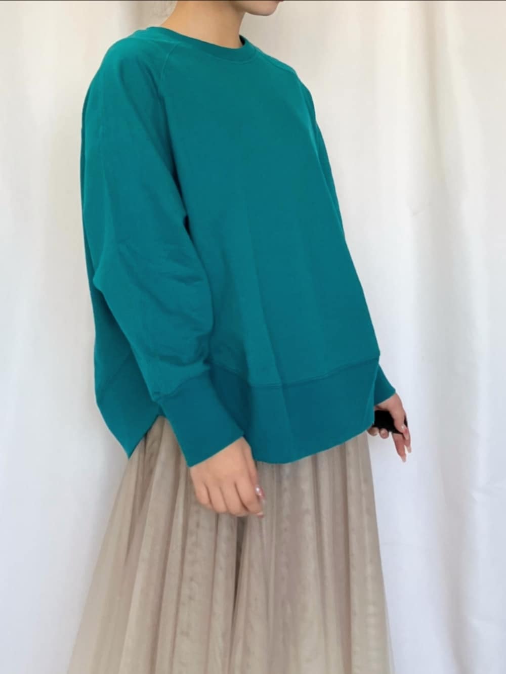 ゴールド系のスカート、グリーン系のスウェット、シルバー系のスニーカーを着用したレディースの冬コーディネートの4枚目の写真