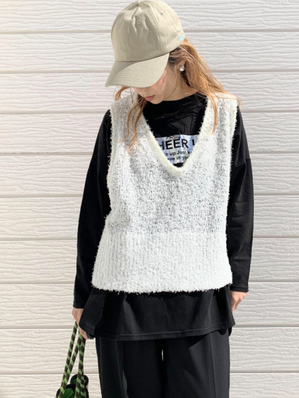 グレー系のトートバッグ、ブラック系のスラックス、ブラック系のTシャツ/カットソーを着用したレディースの冬コーディネートの4枚目の写真