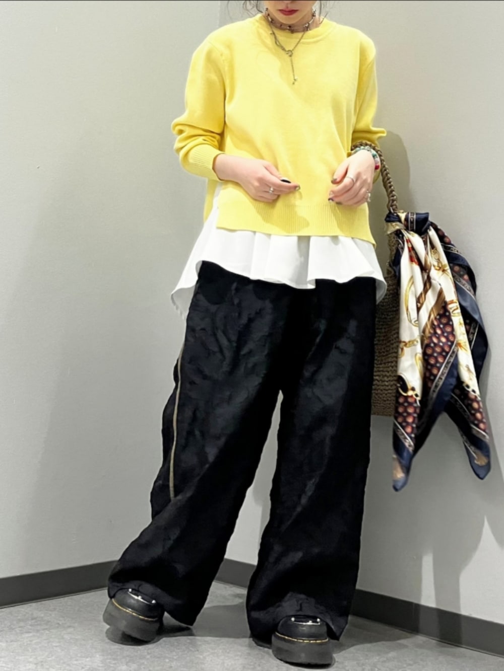 ブラック系のその他パンツ、ベージュ系のトートバッグ、イエロー系のニット/セーターを着用したレディースの春コーディネートの2枚目の写真