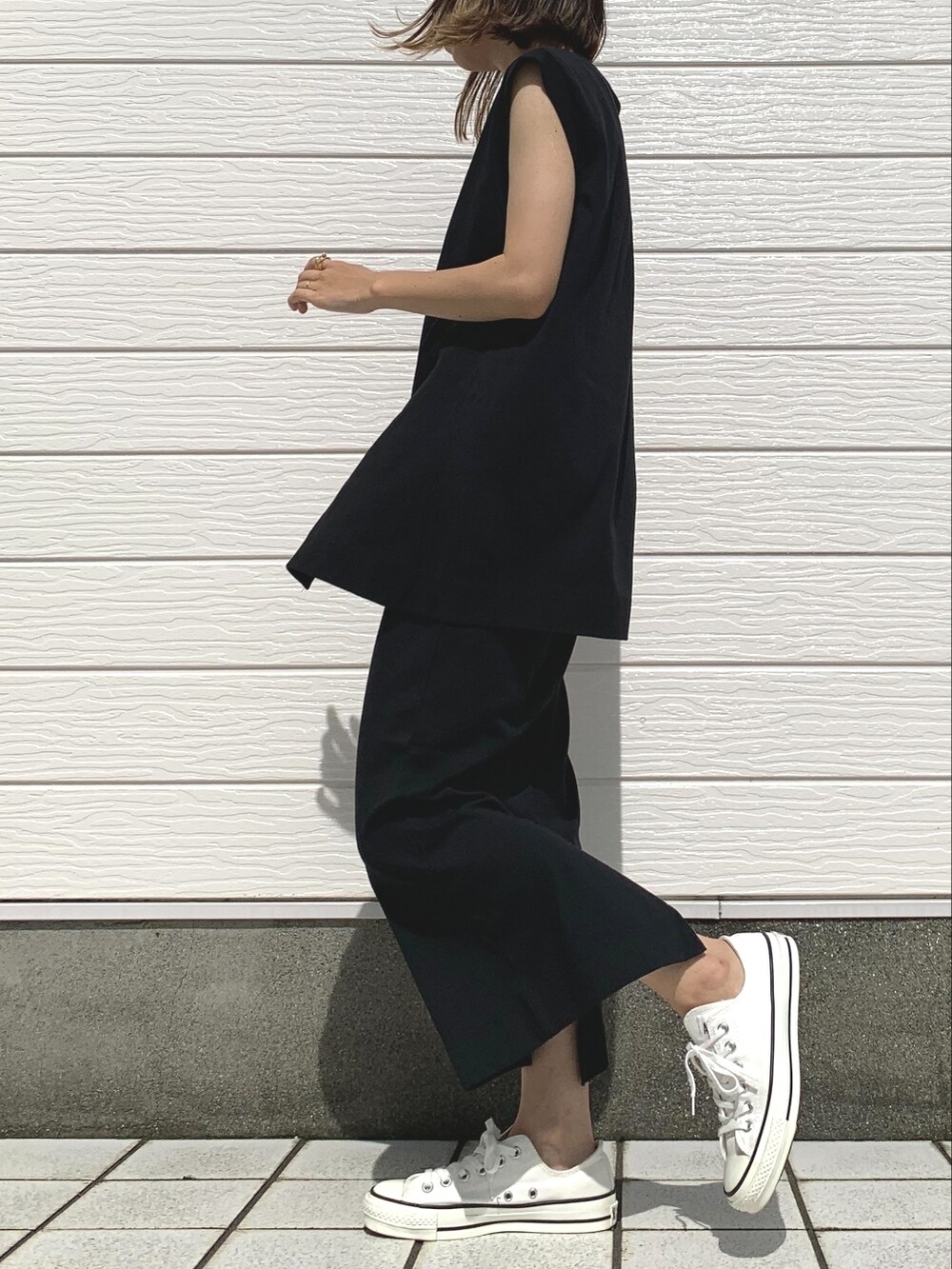 ホワイト系のスニーカー、ブラック系のワンピース、グレー系のカーディガン/ボレロを着用したレディースの夏コーディネートの2枚目の写真