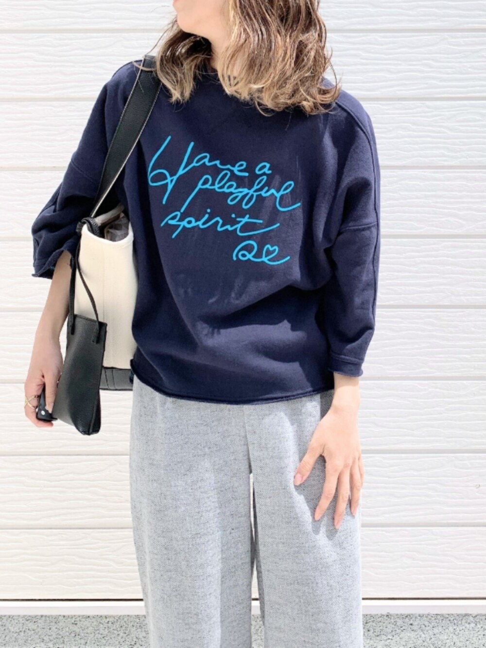 ブルー系のスウェット、グレー系のその他パンツ、ブラック系のハンドバッグを着用したレディースの春コーディネートの3枚目の写真