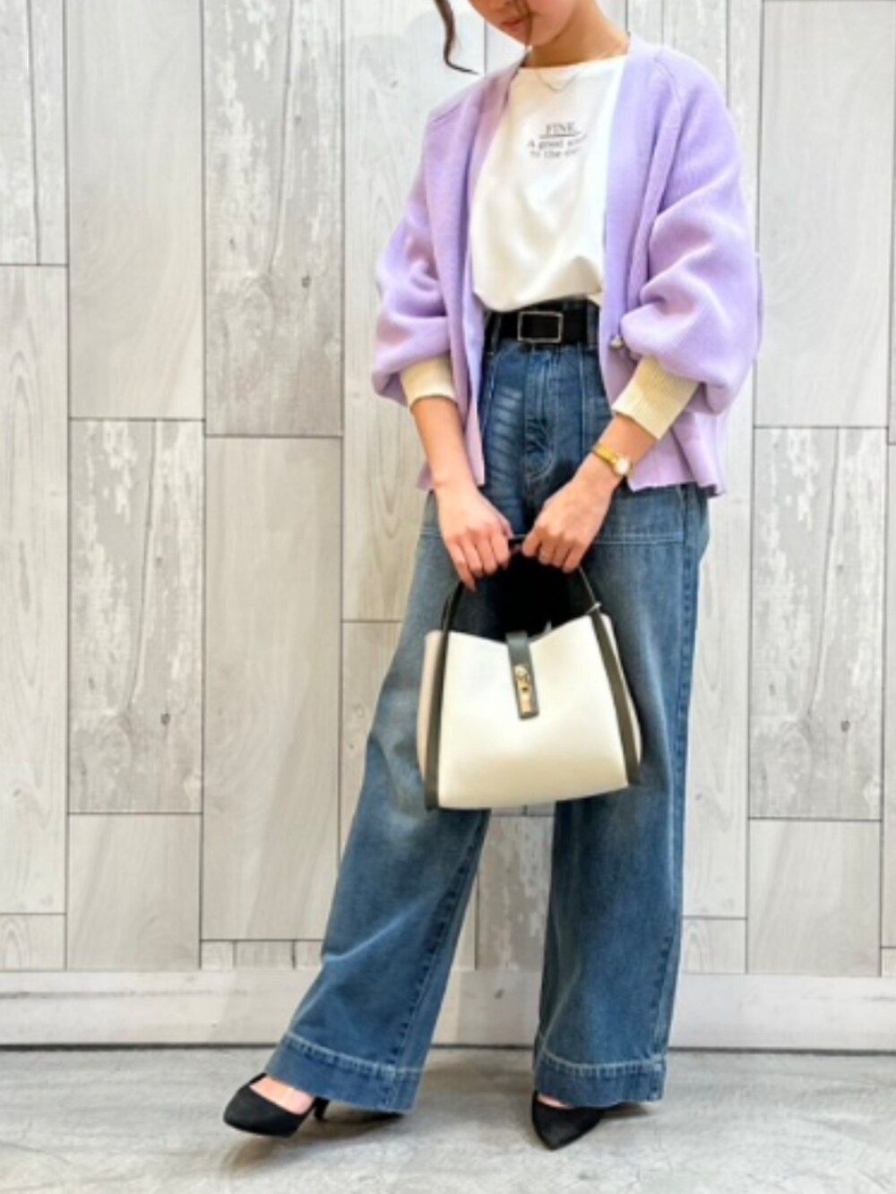 ホワイト系のトートバッグ、ブルー系のデニムパンツ、ホワイト系のTシャツ/カットソーを着用したレディースの冬コーディネートの2枚目の写真