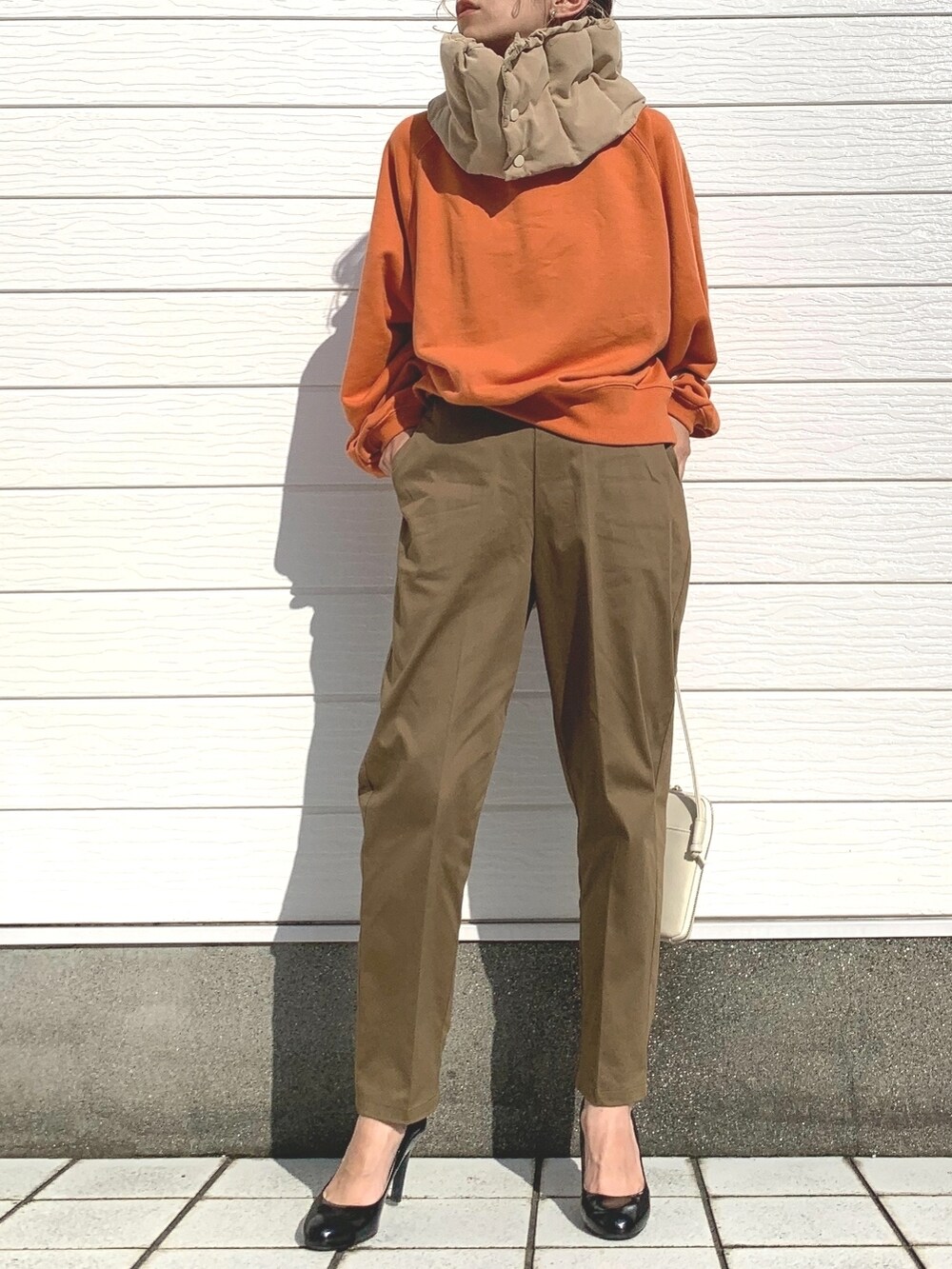 グリーン系のその他パンツ、ホワイト系のショルダーバッグ、オレンジ系のスウェットを着用したレディースの秋コーディネートの2枚目の写真