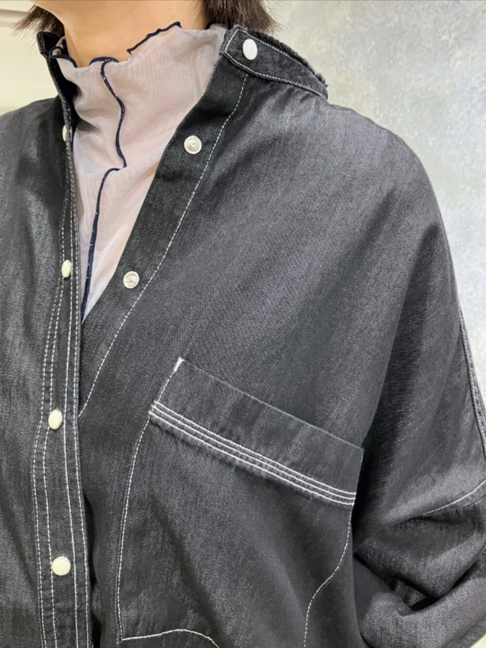 ブラック系のブーツ、グリーン系のスカート、ベージュ系のトートバッグを着用したレディースの秋コーディネートの5枚目の写真