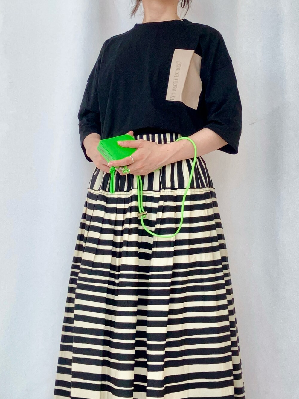 ブラック系のTシャツ/カットソー、グレー系のサンダル、ブラック系のスカートを着用したレディースの夏コーディネートの4枚目の写真