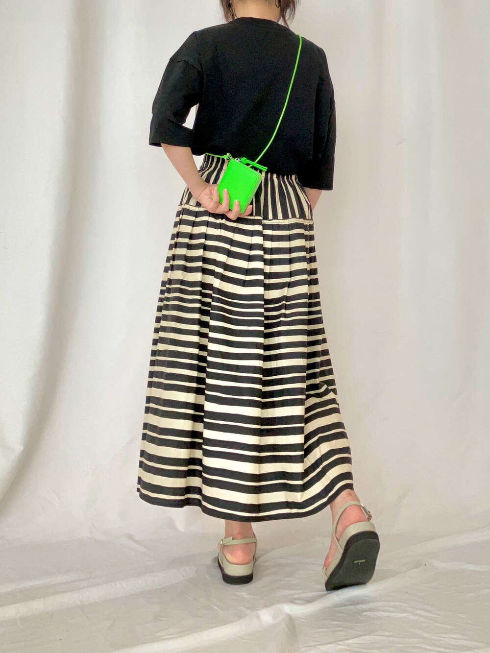 ブラック系のTシャツ/カットソー、グレー系のサンダル、ブラック系のスカートを着用したレディースの夏コーディネートの3枚目の写真