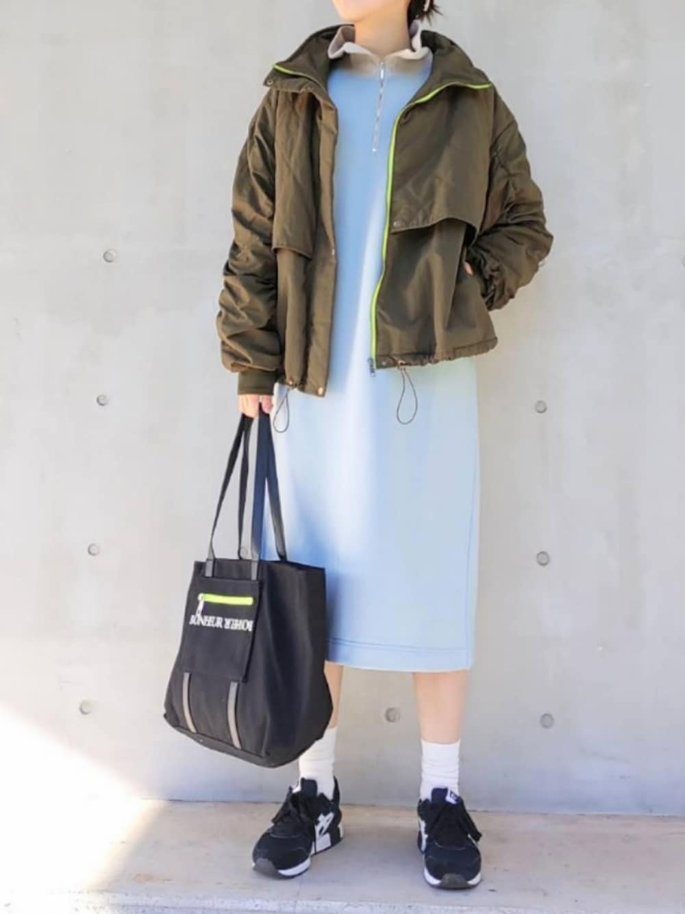 ブラック系のトートバッグ、グリーン系のミリタリージャケット、ブルー系のワンピースを着用したレディースの秋コーディネートの2枚目の写真